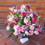 Arreglo floral en base de cerámica cuadrada labrada con lirios stargazer